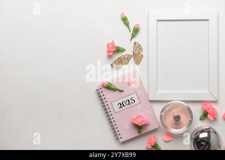 Fotorahmen mit Notizbuch und schönen Blumen auf weißem Hintergrund Stockfoto
