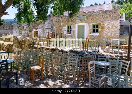 Vor dem Kafenion in Agios Dimitrios standen Holzstühle und -Tische in Vorbereitung auf die Saisoneröffnung auf der Insel Kos i. aufeinander Stockfoto