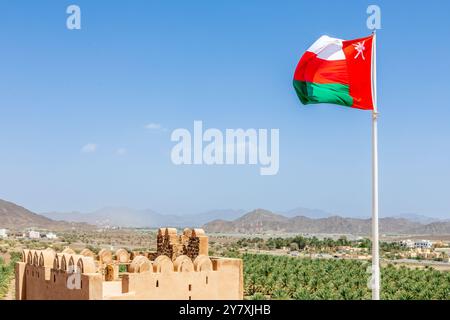 Omanische Flagge winkt im Wind von den Mauern der Burg Jabrin, Bahla, Sultanat Oman Stockfoto