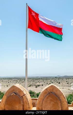 Omanische Flagge winkt im Wind von den Mauern der Burg Jabrin, Bahla, Sultanat Oman Stockfoto