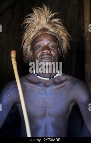 Junger Himba Mann in seiner Hütte, Ohandungu, Kunene Region, Kaokoveld, Namibia, Afrika Stockfoto