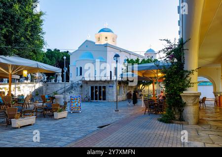 Platia Agias Paraskevis mit Blick auf die Kirche Agia Paraskevi und Arkade der Markthalle am Abend in Kos Stadt auf der Insel Kos in Griechenland Stockfoto