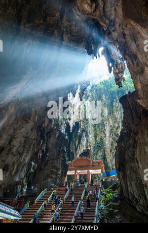Batu Caves Interior, Selangor, Malaysia. Touristen besuchen die beleuchtete Treppe des Batu-Höhlenkomplexes mit Menschen durch natürliches Licht, das durch die strömt Stockfoto