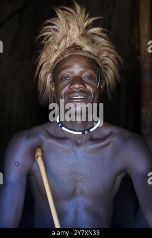 Junger Himba Mann in seiner Hütte, Ohandungu, Kunene Region, Kaokoveld, Namibia, Afrika Stockfoto