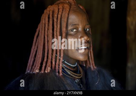 Die junge Himba-Frau in ihrer Hütte, Ohandungu, Kunene Region, Kaokoveld, Namibia, Afrika Stockfoto