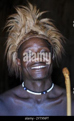 Junger Himba Mann in seiner Hütte, Ohandungu, Kunene Region, Kaokoveld, Namibia, Afrika Stockfoto