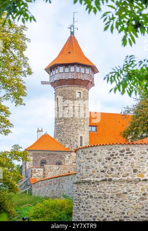 Der Aussichtsturm der Burg Hnevin steht hoch über dem Himmel, mit unverwechselbaren roten Dächern und Steinmauern, umgeben von üppigem Grün, und zeigt seine architektonische Schönheit in den meisten Tschechien. Stockfoto