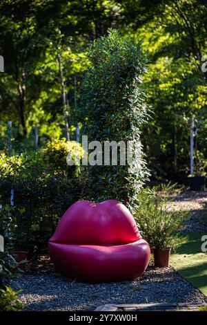 Gartendekor rote Lippenbank an sonnigen Tagen Stockfoto