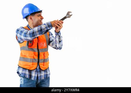 Copyspace-Bauarbeiter ziehen eine Schraube mit einem Schraubenschlüssel fest, während sie eine orangefarbene reflektierende Weste und einen blauen Schutzhelm tragen. Zeigt die Pre Stockfoto