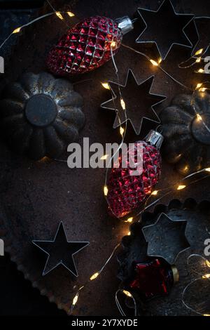 Alte Keksschneider auf der Dose mit alten Weihnachtsbaumschmuck und Feenlichtern Stockfoto