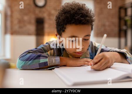 afroamerikaner, der Unterricht macht und etwas in ein Notizbuch schreibt Stockfoto