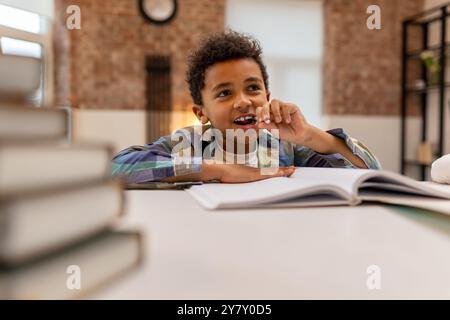 Dunkelhäutiger, süßer Junge, der Unterricht macht und sich beteiligt sieht Stockfoto