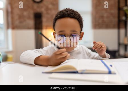 afroamerikaner, der Unterricht macht und etwas in ein Notizbuch schreibt Stockfoto