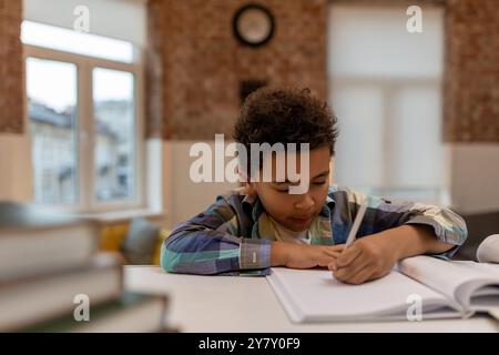 afroamerikaner, der Unterricht macht und etwas in ein Notizbuch schreibt Stockfoto