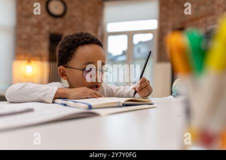 afroamerikaner, der Unterricht macht und etwas in ein Notizbuch schreibt Stockfoto