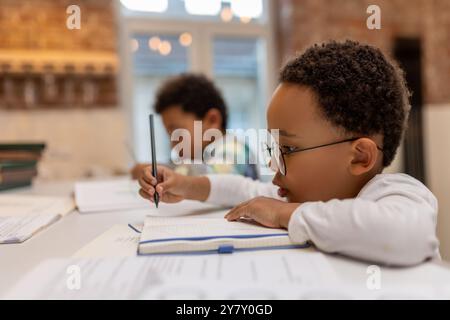 afroamerikaner, der Unterricht macht und etwas in ein Notizbuch schreibt Stockfoto