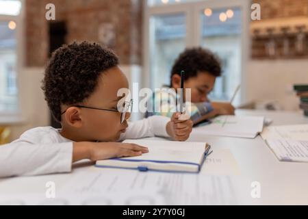 afroamerikaner, der Unterricht macht und etwas in ein Notizbuch schreibt Stockfoto