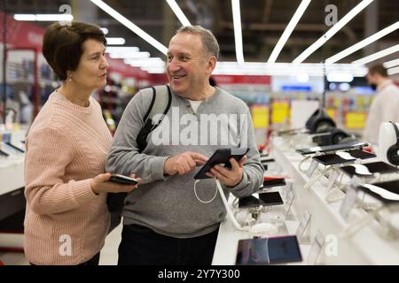 Seniorenpaar, das sich im Technikgeschäft für ein Tablet entschieden hat Stockfoto