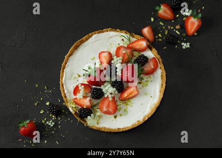 Mini-Käsekuchen ohne Backen mit Erdbeeren, Brombeeren und Holunderblüten Stockfoto