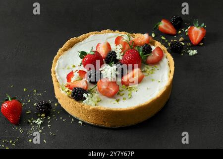 Mini-Käsekuchen ohne Backen mit Erdbeeren, Brombeeren und Holunderblüten Stockfoto