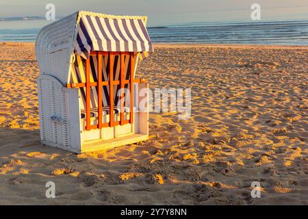 Strandkorb Liegestühle am Strand in Swinoujscie, Polen, während Sonnenaufgang an der Ostseeküste Stockfoto