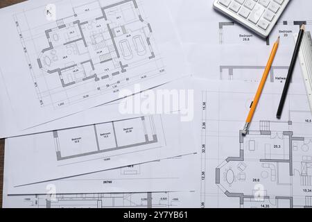 Verschiedene Architekturzeichnungen, Taschenrechner und Bleistifte auf dem Tisch, Draufsicht Stockfoto