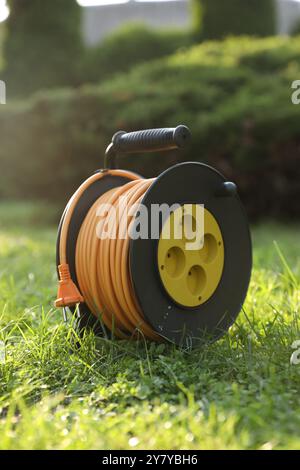 Eine Verlängerungskabelrolle auf grünem Gras im Freien Stockfoto