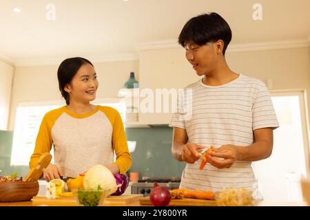 Gemüse zubereiten, asiatische Geschwister und Geschwister, die zusammen in der modernen Küche kochen Stockfoto