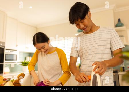 Gemüse zubereiten, asiatische Geschwister kochen zusammen in der modernen Küche und genießen die Zeit Stockfoto