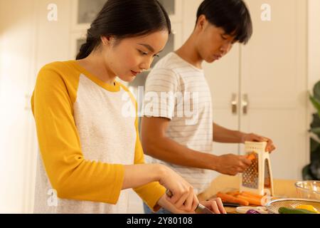 Kochen zusammen in der Küche, junge asiatische Bruder und Schwester bereiten Gemüse für gesunde Mahlzeiten Stockfoto