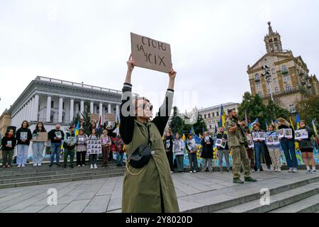 KIEW, UKRAINE - 01. SEPTEMBER 2024 - Eine Frau hält ein Plakat während einer landesweiten Schweigeminute zum Gedenken an gefallene Soldaten am Tag der Verteidiger der Ukraine am Unabhängigkeitsdenkmal auf dem Maidan-Nezalezhnosti-Platz in Kiew, Hauptstadt der Ukraine Stockfoto