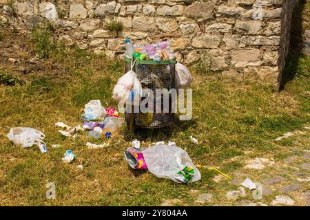 Berat, Albanien - 2. Juni 2024. Ein überlaufender Abfalleimer, der auf dem Boden verstreut ist, zeigt die Umweltprobleme auf, denen touristische Reiseziele gegenüberstehen Stockfoto