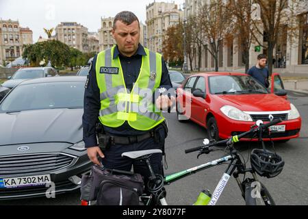 Nicht exklusiv: KIEW, UKRAINE - 01. SEPTEMBER 2024 - Ein Polizist mit einem Fahrrad und die Fahrer auf der Straße nehmen an einer landesweiten Schweigeminute Teil i Stockfoto