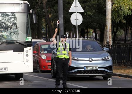 Nicht exklusiv: DNIPRO, UKRAINE - 01. OKTOBER 2024 - Ein Polizist blockiert den Verkehr während einer landesweiten Schweigeminute zum Gedenken an gefallene Soldaten Stockfoto