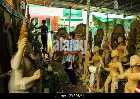 Besucher machen Selfies mit Tongöttern, die für das Durga Puja Festival in Sylhet, Bangladesch, vorbereitet werden. Durga Puja ist das bedeutendste religiöse und kulturelle Festival für Hindus, das in ganz Bangladesch mit großer Begeisterung, lebhaften Festen und tiefer religiöser Hingabe gefeiert wird. Stockfoto