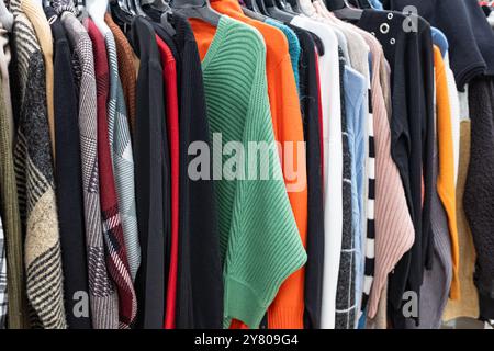 Damenbekleidung – Herbst Winter Kollektion. Modische Strickkleidung, hängend an Regalen zur Ausstellung. Lässige Damen-Pullover, Angebotssaison. Mehrfarbiges W Stockfoto