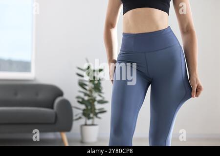 Frau trägt blaue Sportleggings drinnen, Nahaufnahme Stockfoto