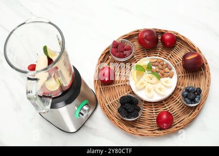 Mixer und frische Zutaten auf weißem Marmortisch Stockfoto