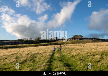 Zwei Läufer bei Newbiggin Crags, einer Kalksteinpflasterlandschaft in der Nähe von Burton in Lonsdale, Cumbria, England. Stockfoto