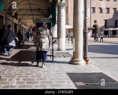 Mantua, Italien 30. September 2024 Frau, die an einem sonnigen Tag unter den Bögen des historischen Zentrums von mantua, italien, spaziert Stockfoto