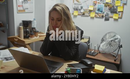 Eine nachdenkliche junge Frau sitzt an ihrem überfüllten Detektivbüro, umgeben von Beweismitteln und Ermittlungsmitteln. Stockfoto
