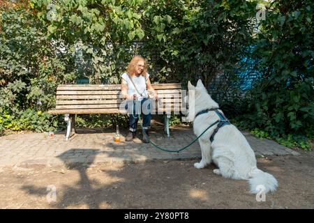 Bank ältere Frau Hund in Berlin Görlitzer Park Stadtbezirk Kreuzberg Berlin Deutschland Europa Stockfoto