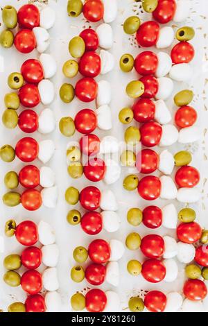 Frische Spieße mit Kirschtomaten, Mozzarella und grünen Oliven auf einem Buffettisch Stockfoto