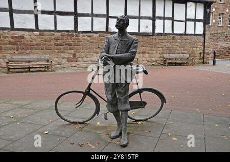 Eine Statue des Komponisten Sir Edward Elgar, der auf seinem Fahrrad Mr. Phoebus in der Kathedrale lehnt und auf die Hereford Cathedral blickt. Die Skulptur wurde von Jemma Pearson gestaltet Stockfoto