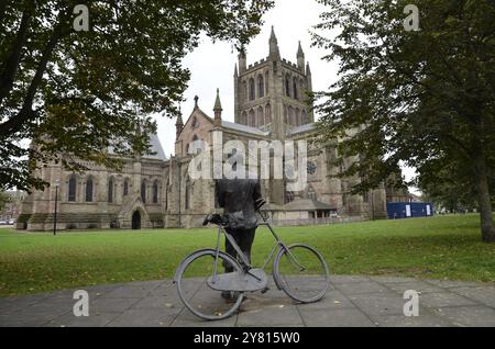 Eine Statue des Komponisten Sir Edward Elgar, der auf seinem Fahrrad Mr. Phoebus in der Kathedrale lehnt und auf die Hereford Cathedral blickt. Die Skulptur wurde von Jemma Pearson gestaltet Stockfoto