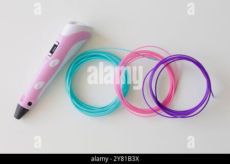 3D-Stift, Kit mit farbigen Kunststofffilamenten auf weißem Tisch Stockfoto