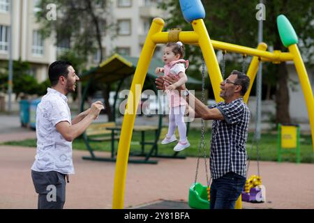 Gaziantep, Türkei. Mai 2022. Der syrische Großvater Kamal Khatib spielt mit seinem Enkel auf einem Spielplatz in Gaziantep. Kamal und sein Sohn Bashir wurden getrennt, als Kamal vor dem Krieg floh, um in Jordanien Zuflucht zu suchen. Erst zehn Jahre später, als Kamal in die Türkei reisen konnte, um seine sehr aggressive Krebsform behandeln zu lassen, kam er mit seinem Sohn wieder zusammen, der jetzt mit seiner Frau und zwei kleinen Kindern in der Türkei lebt. Das Ereignis verdeutlicht die Tragödie des Krieges in Syrien, in dem die Syrer in einem nie endenden Konflikt gefangen sind, der ihnen große Verluste, Vertreibungen und immenses Leid verursacht Stockfoto