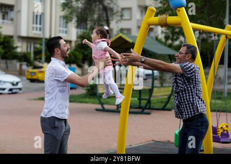 Gaziantep, Türkei. Mai 2022. Der syrische Großvater Kamal Khatib spielt mit seinem Enkel auf einem Spielplatz in Gaziantep. Kamal und sein Sohn Bashir wurden getrennt, als Kamal vor dem Krieg floh, um in Jordanien Zuflucht zu suchen. Erst zehn Jahre später, als Kamal in die Türkei reisen konnte, um seine sehr aggressive Krebsform behandeln zu lassen, kam er mit seinem Sohn wieder zusammen, der jetzt mit seiner Frau und zwei kleinen Kindern in der Türkei lebt. Das Ereignis verdeutlicht die Tragödie des Krieges in Syrien, in dem die Syrer in einem nie endenden Konflikt gefangen sind, der ihnen große Verluste, Vertreibungen und immenses Leid verursacht Stockfoto