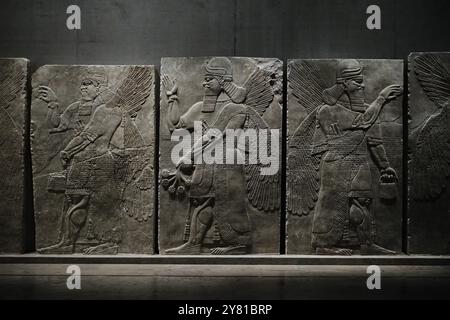 München, Deutschland - 17. April 2024: Geflügelte und bärtige Dschinken mit verschiedenen Attributen, Assyrisches Flachrelief im Ägyptischen Staatsmuseum Stockfoto