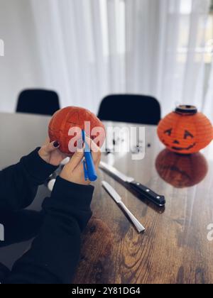 Abgeschnittene Aufnahme von Frauen, die große Orange schnitzen Stockfoto